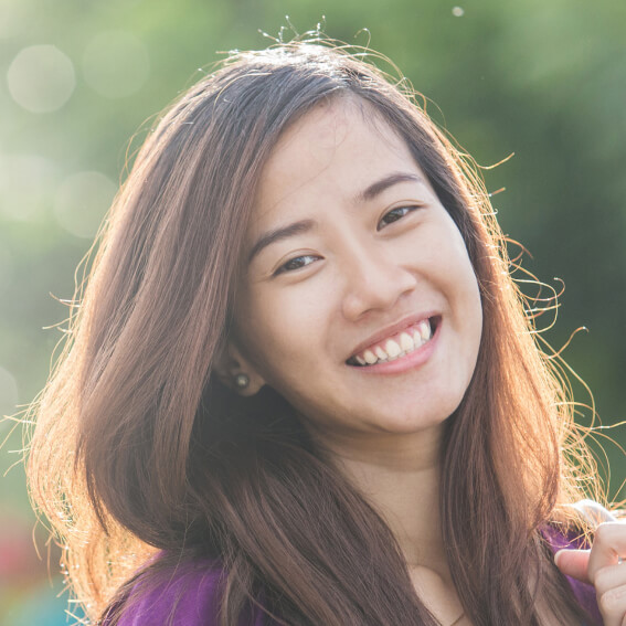 a young girl smiling while outside